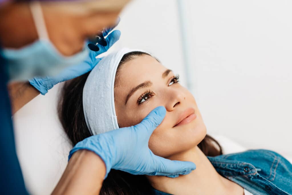 Provider performing an aesthetic facial assessment before treatment at Timeless Youth MD in West Des Moines