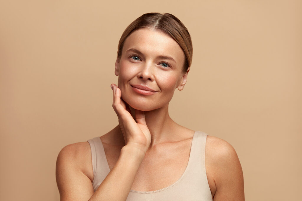 Woman touching her jawline while considering facial rejuvenation options such as PDO threads and dermal fillers. Woman touching her jawline while considering facial rejuvenation options such as PDO threads and dermal fillers.